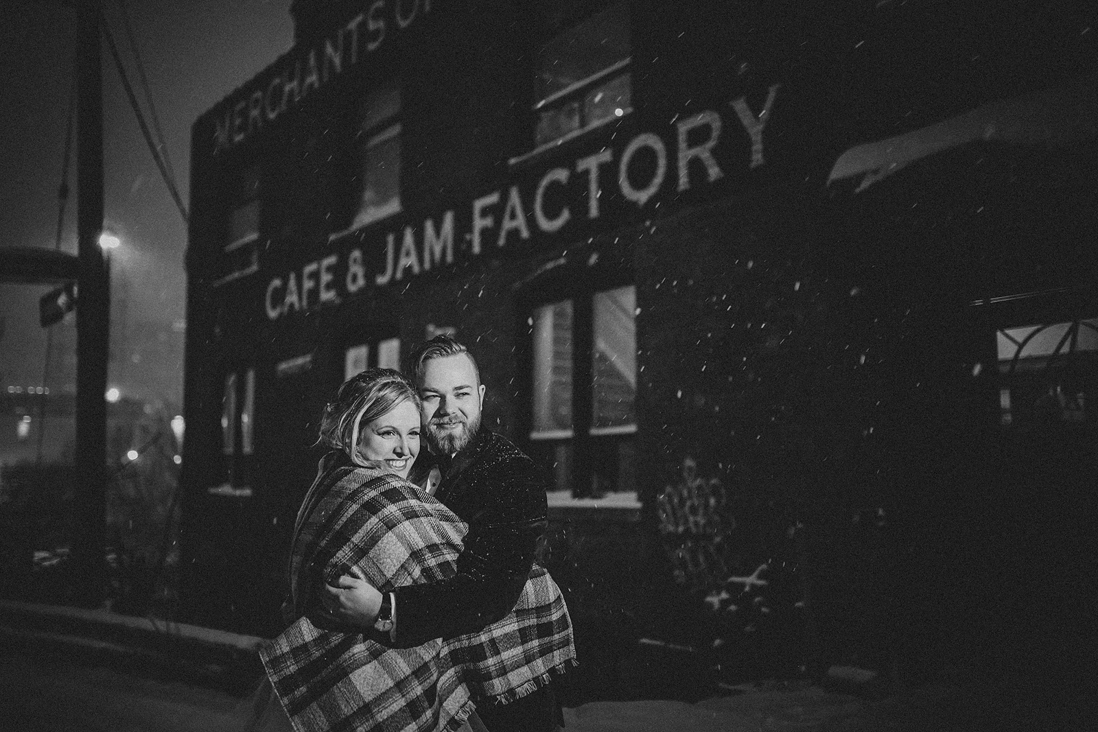 A bride and groom embrace in front of the Jam Factory in Toronto