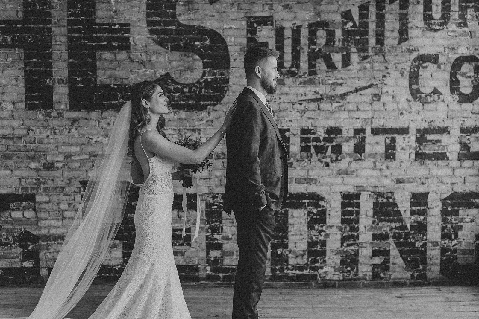 a bride taps her groom on the back, signalling for him to turn around to see her for the first look
