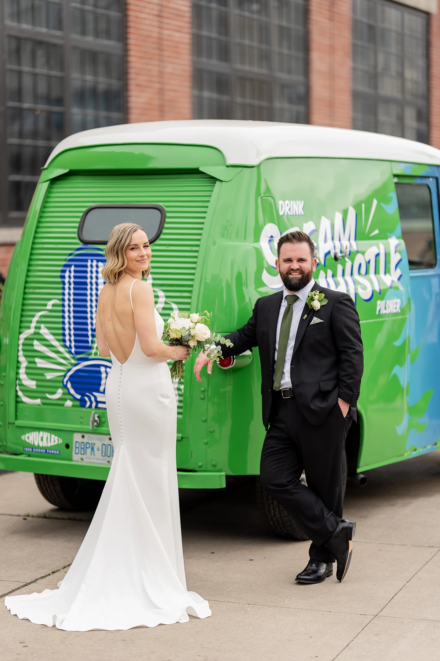 Bride and groom stand in front of Steam Whistle Brewing