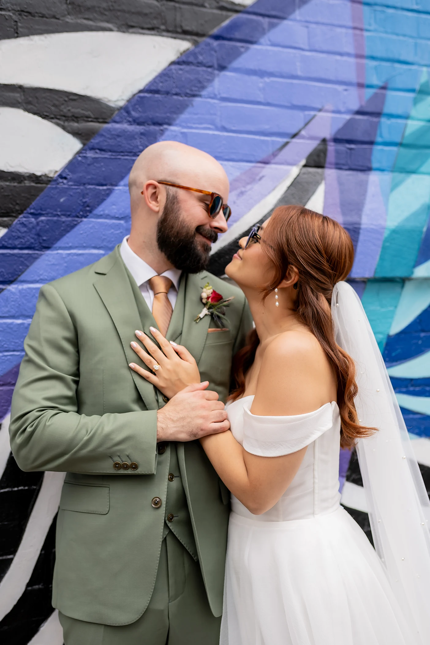 Bride and groom in front of graffiti wall