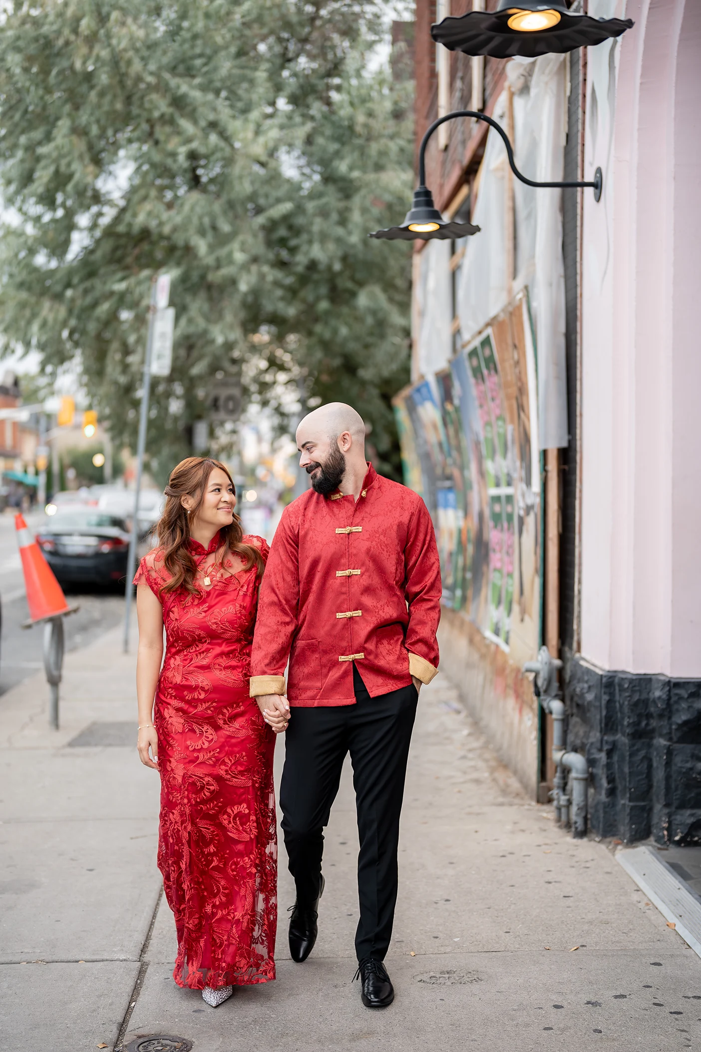 Bride and Groom walk together wearing traditional Chinese wedding outfits