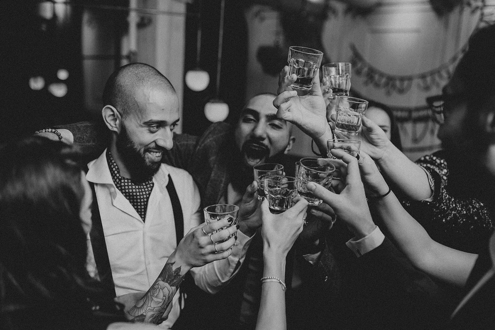 glasses brought together in a toast with the groom