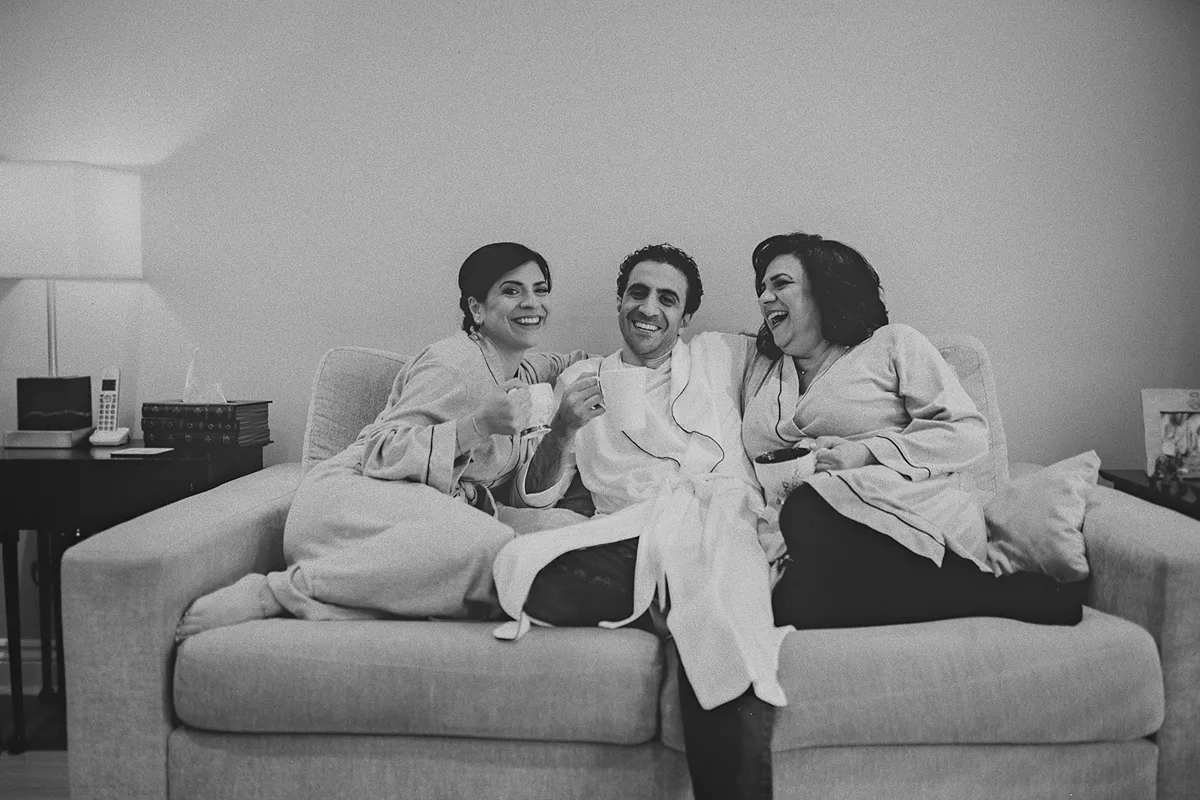 Mike laughs with his mother and sister on the couch