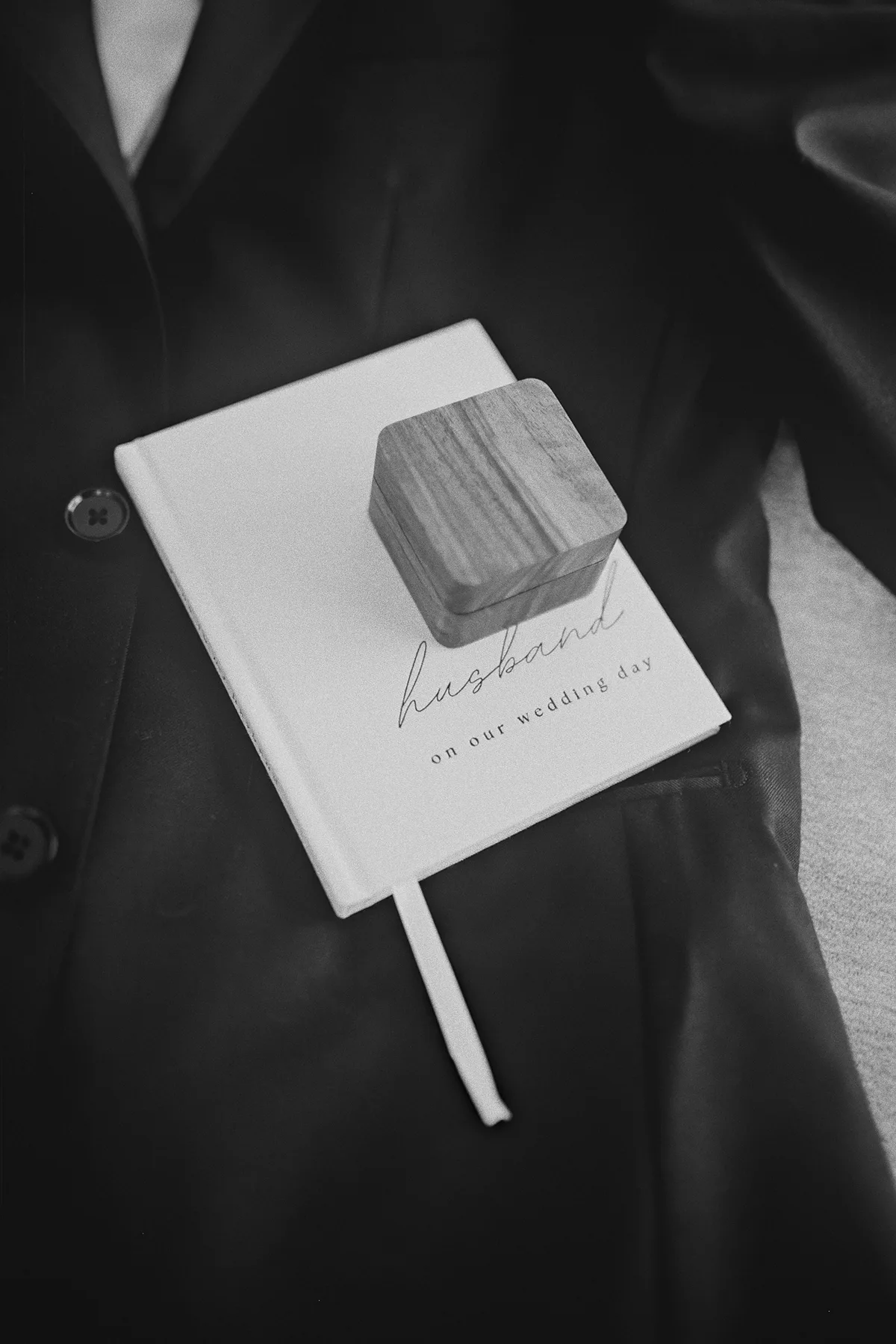 Mike's vow book and ring box on his suit jacket