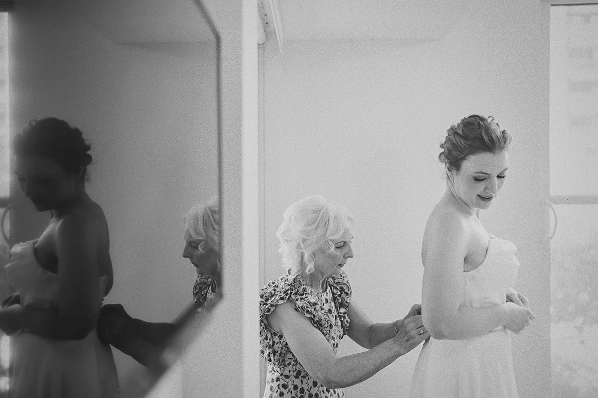 Beth gets help with her dress from her mother