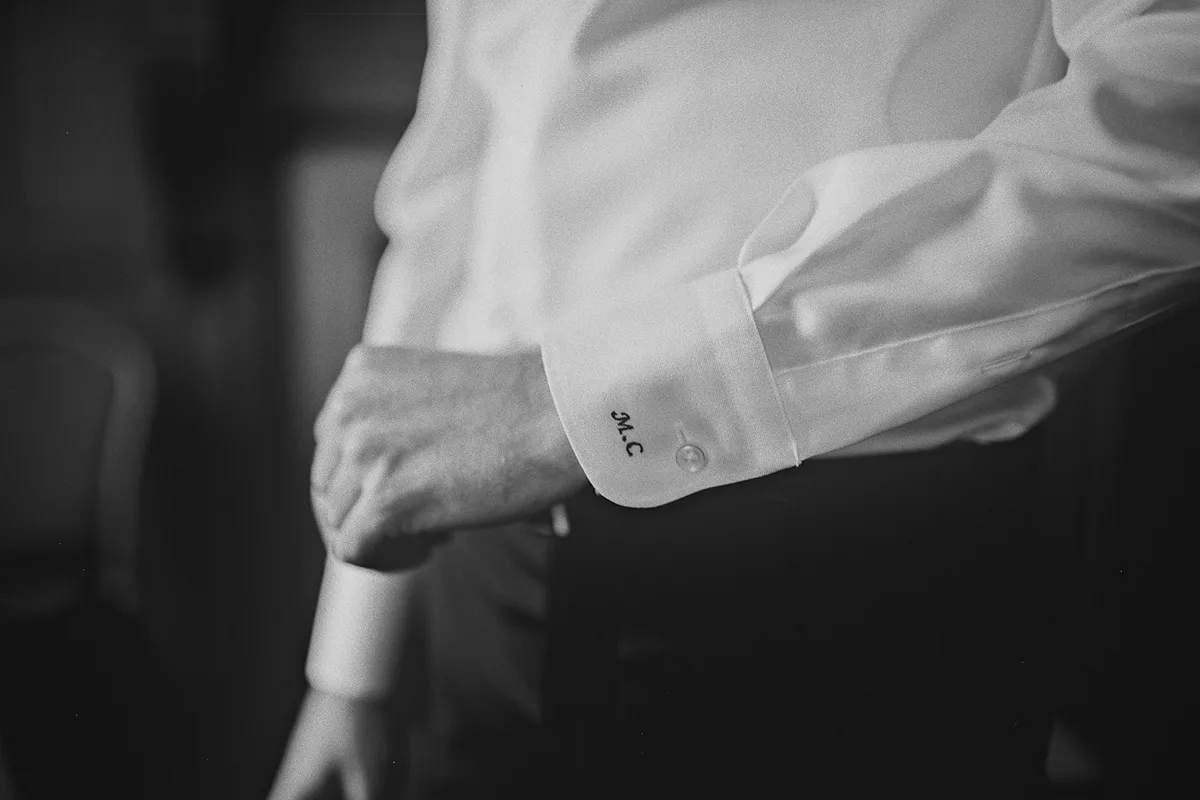 A close-up of the groom's monogrammed shirt cuff
