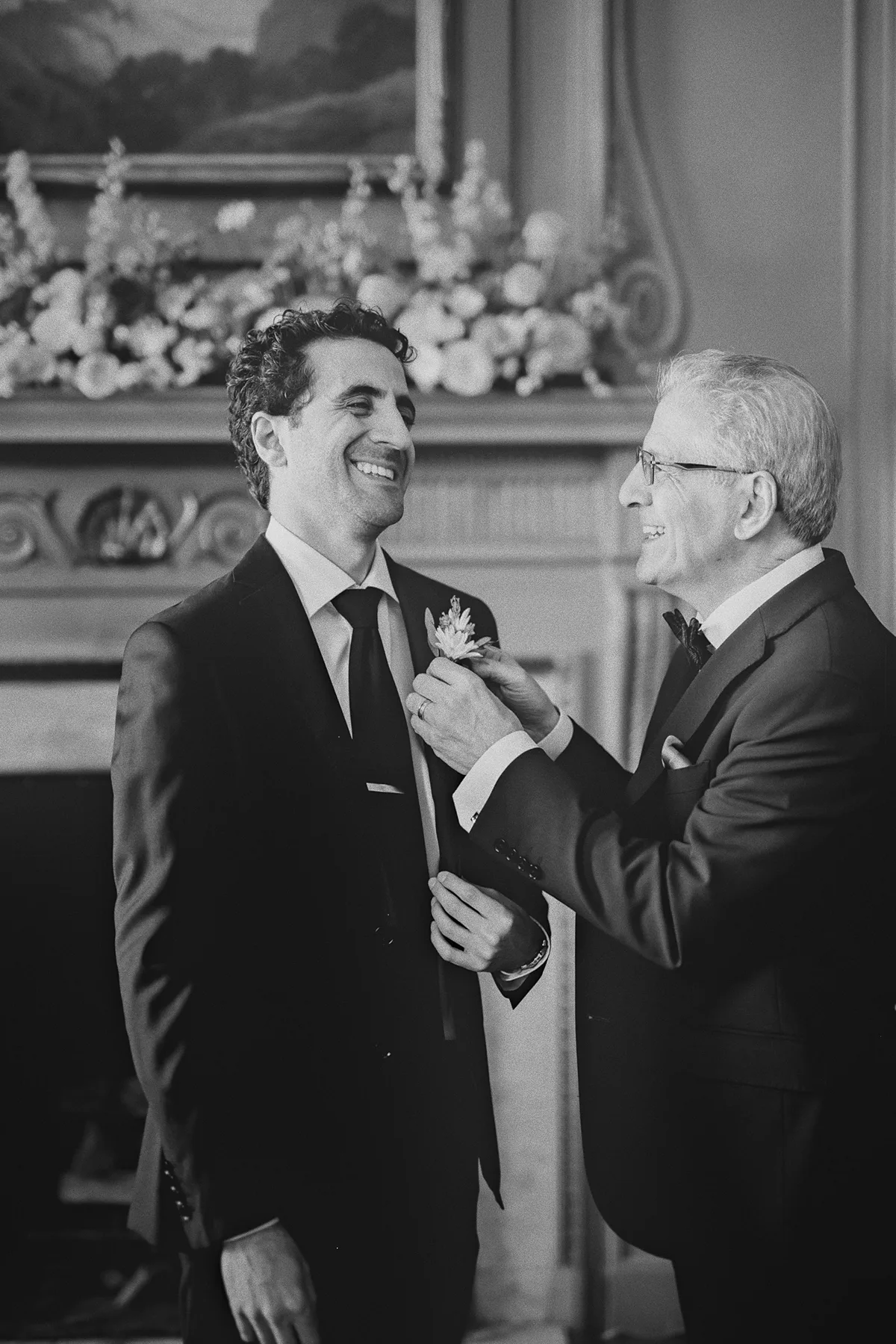 Mike smiles as a father pins on his boutonniere