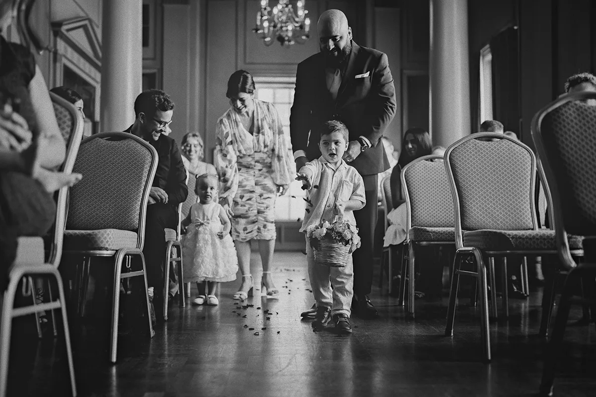 The ring bearer throws petals down the aisle