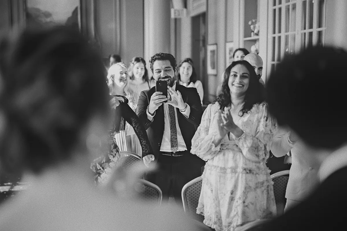 Guests applaud and take photos of the newlyweds