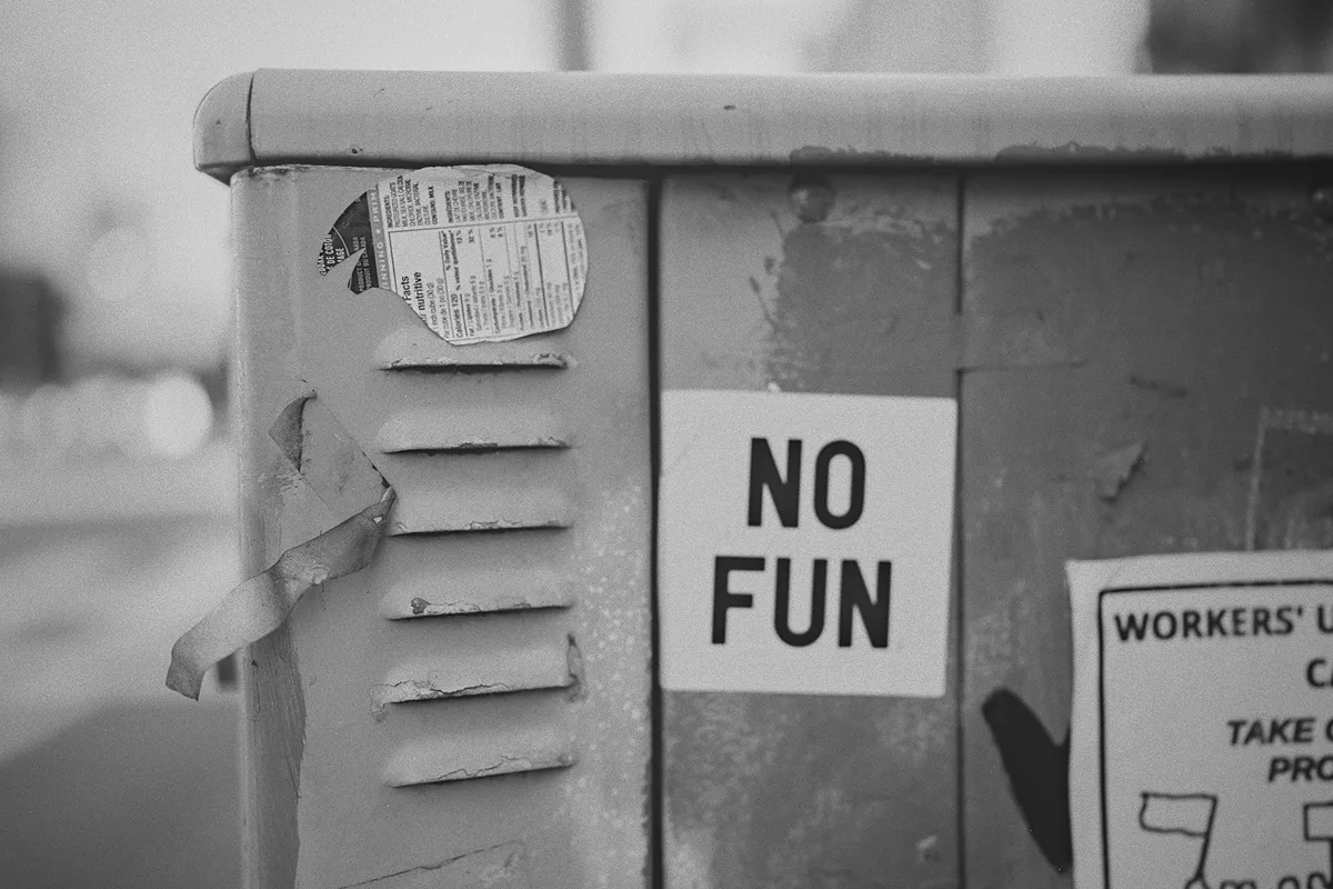 A quirky detail of a 'NO FUN' sticker found on the street