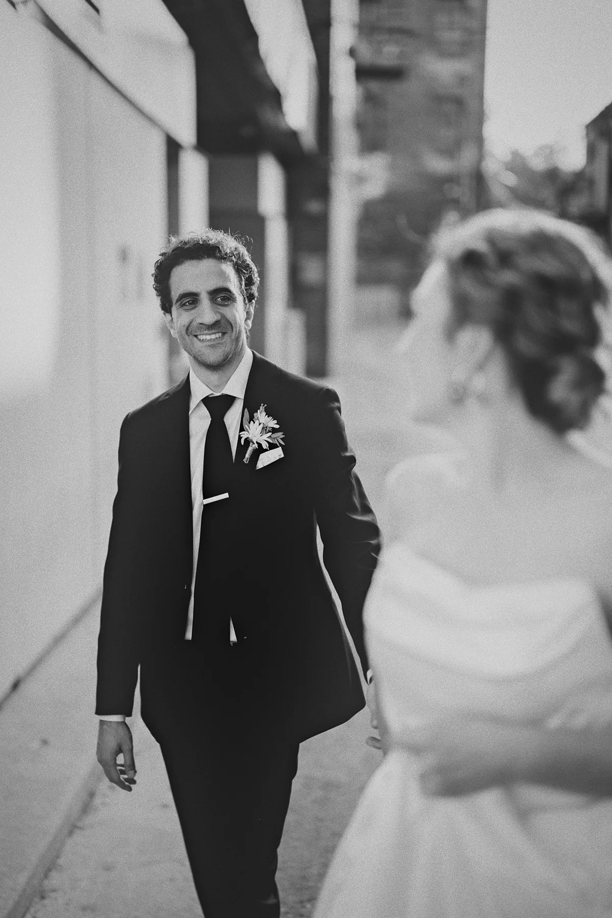 Mike smiles as he follows his bride