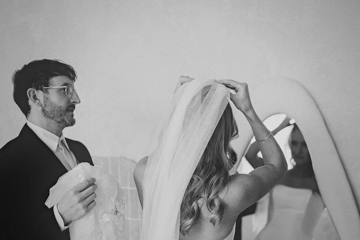 Mark watches as Carolyn puts on her wedding veil