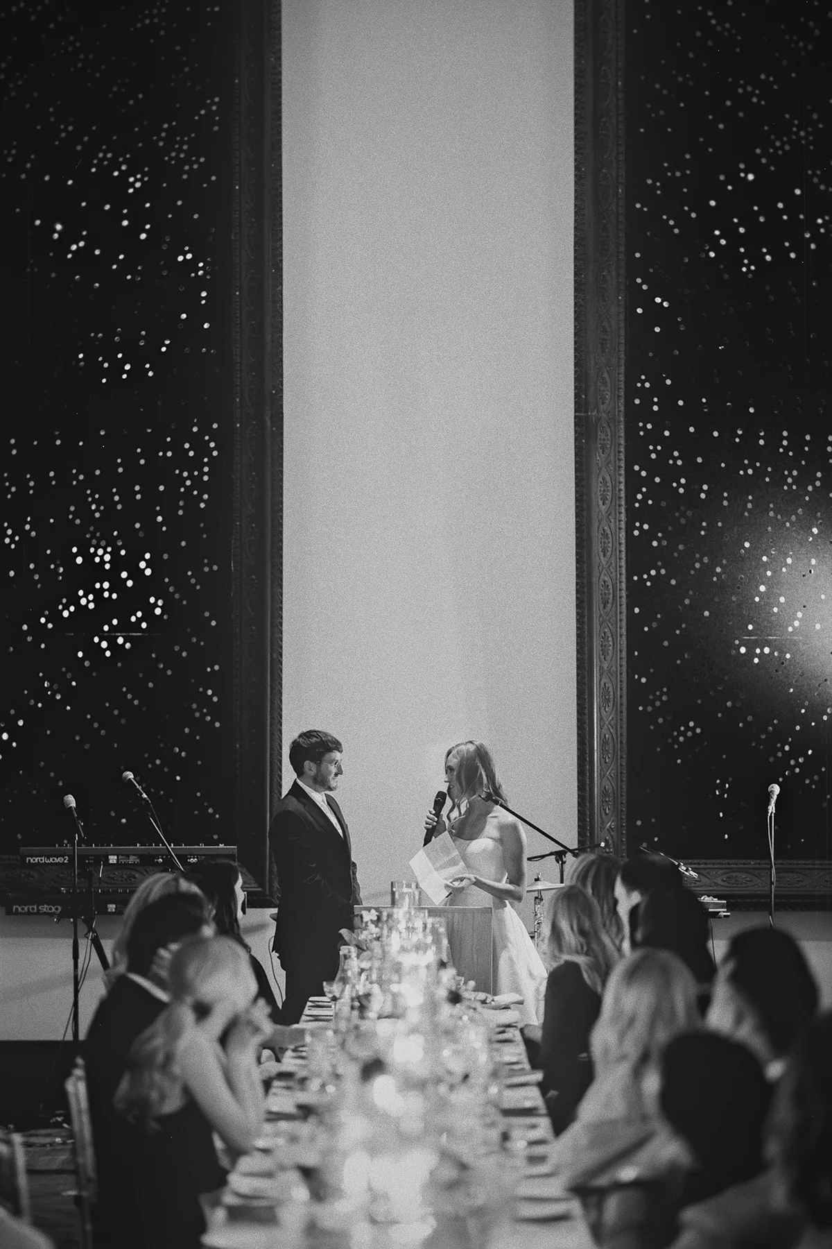 A wide shot of Carolyn and Mark giving their speech