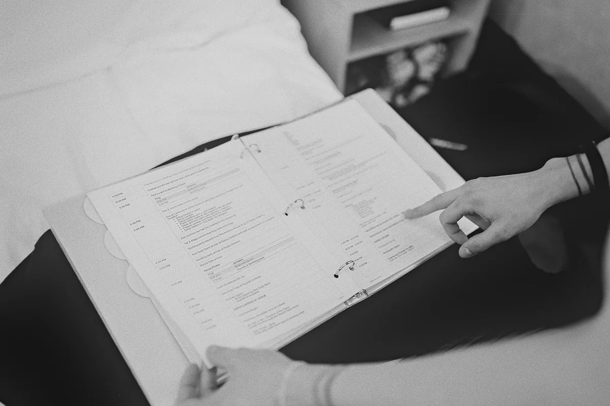 A groomsman reviews the wedding day binder