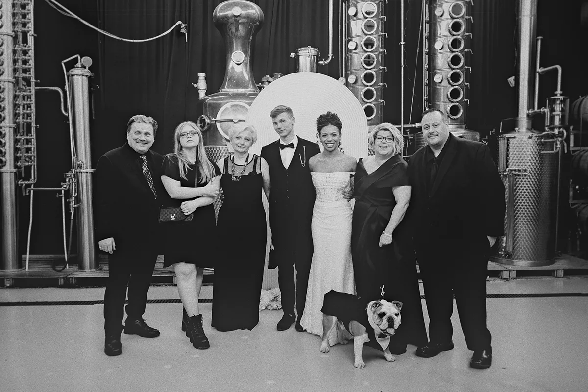 The couple poses with family and their bulldog.
