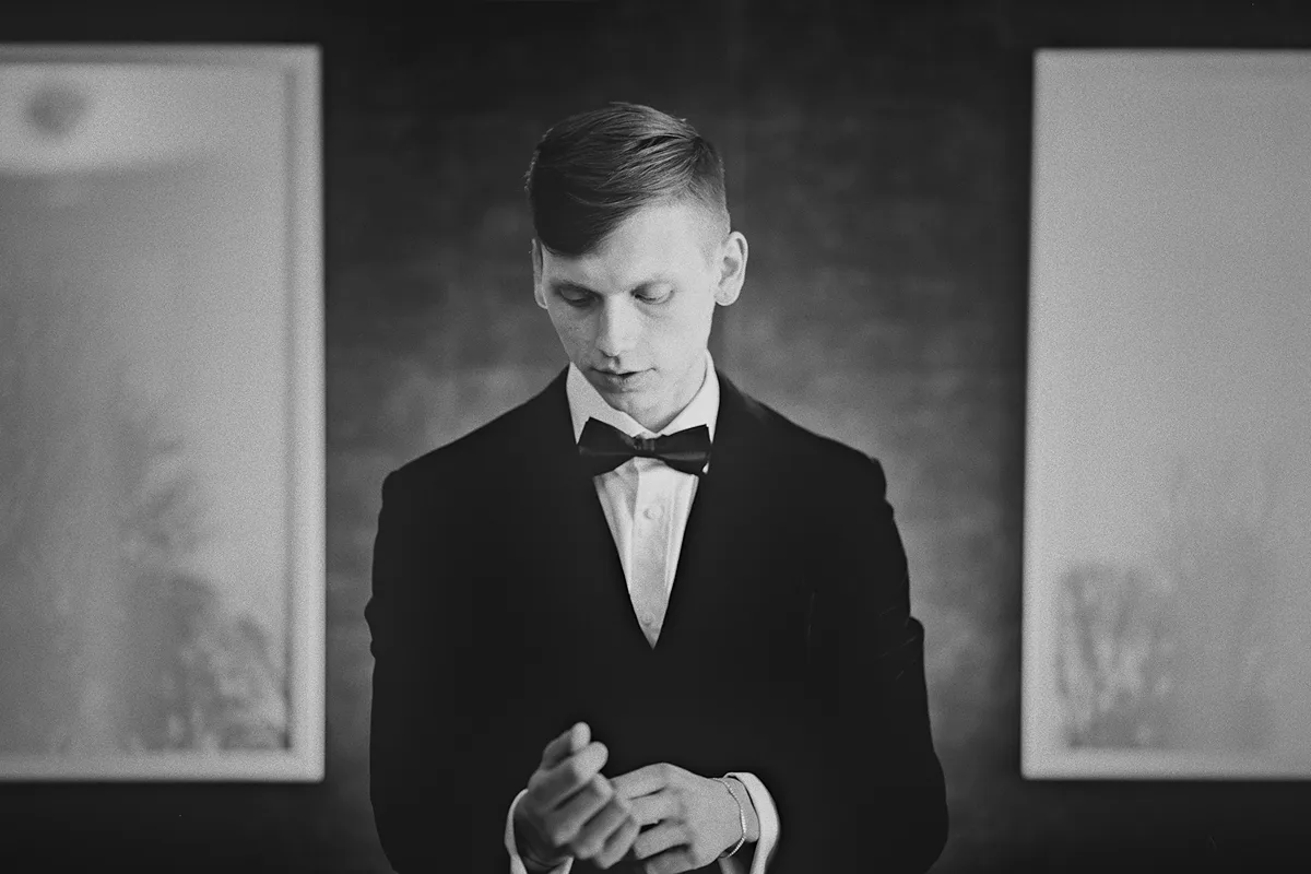 A portrait of Konrad adjusting his cufflinks