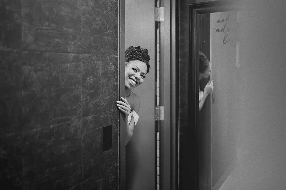 Cherise peeks out playfully before putting on her dress
