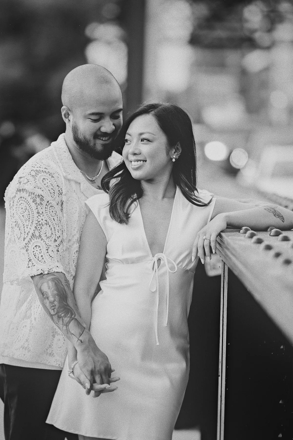 A romantic, candid-style portrait of the couple on a bridge.