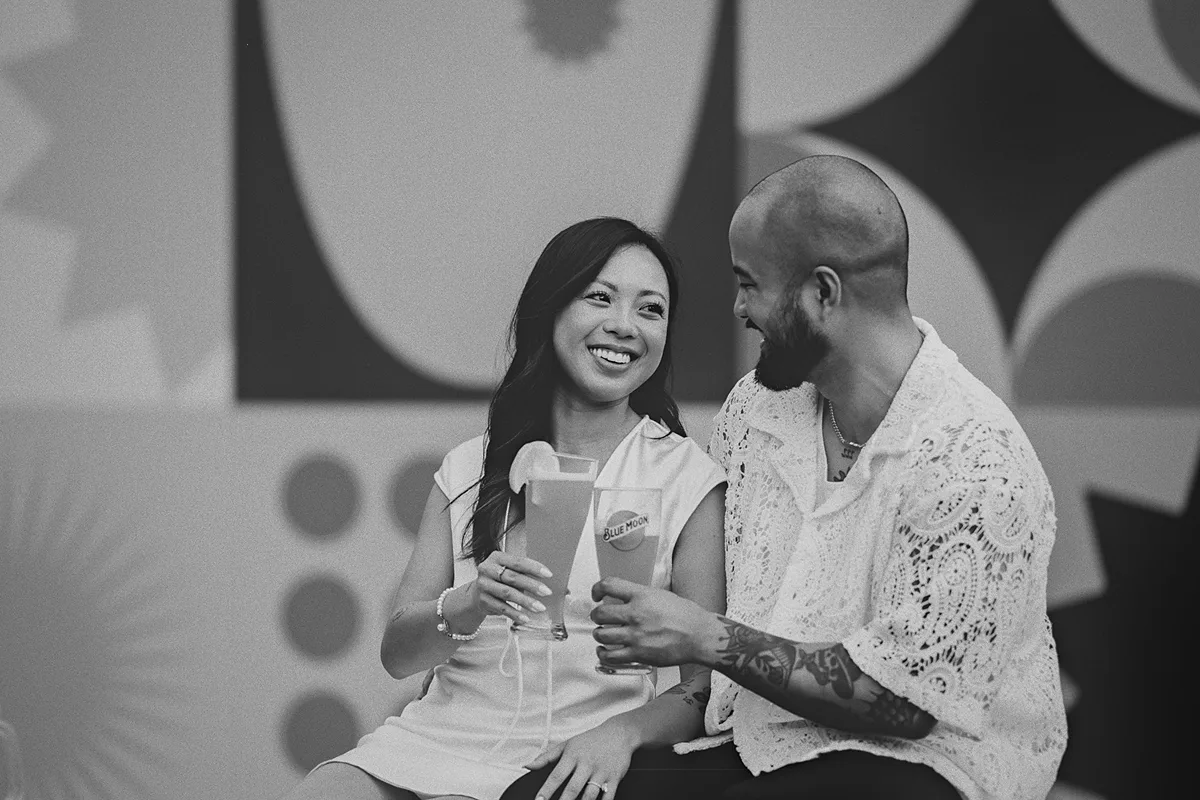 A joyful, candid moment as the couple enjoys a drink.