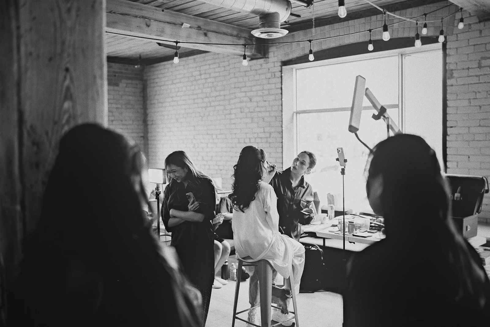 Corrina gets her makeup done surrounded by her wedding party