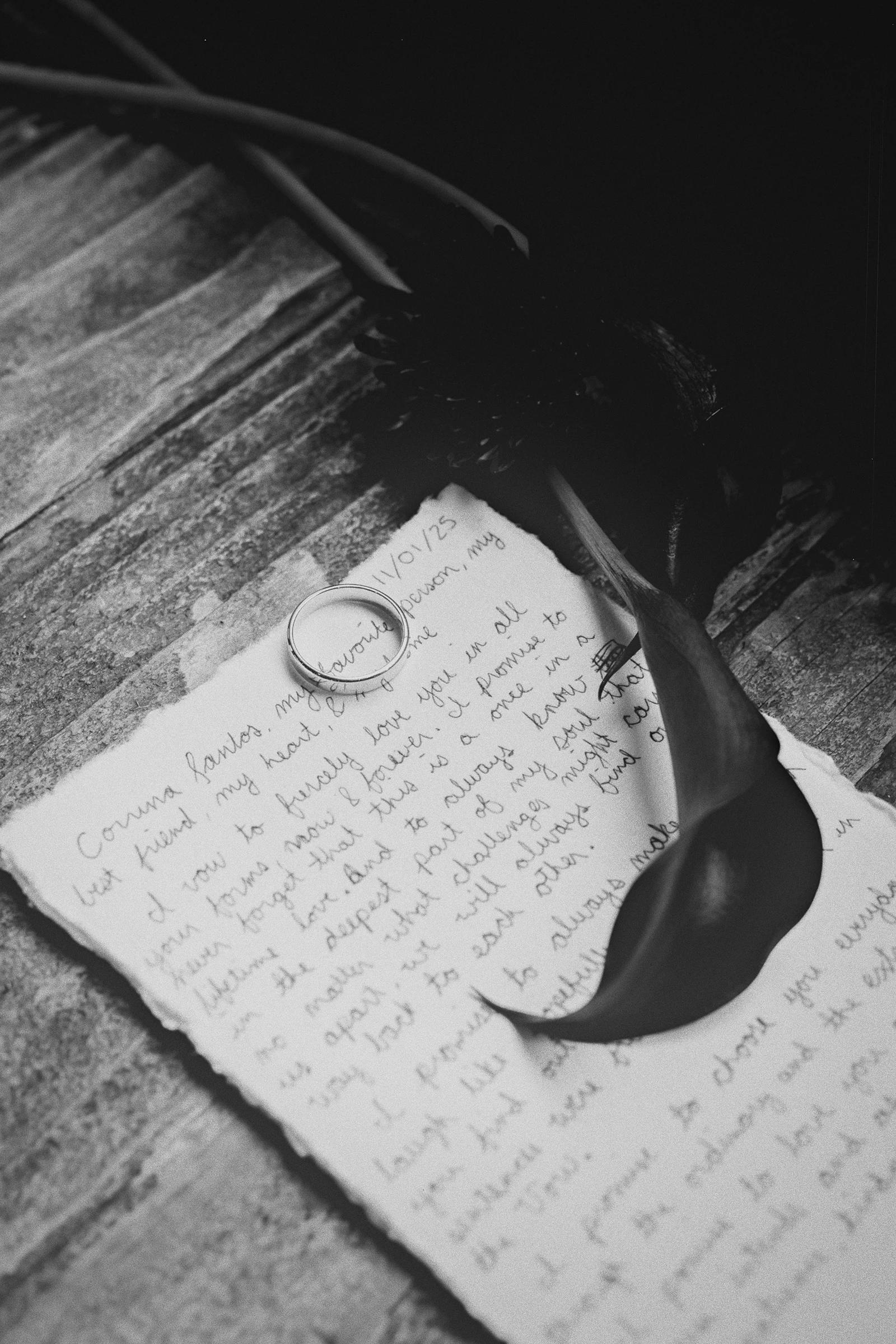 A detail shot of handwritten vows and a wedding ring