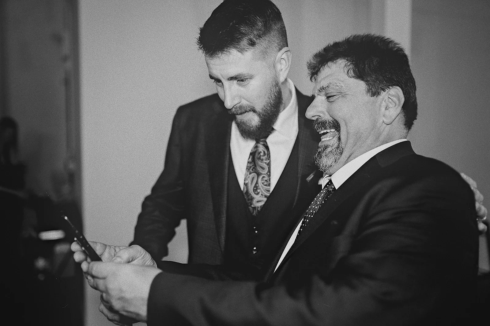 Ryan and a guest laugh while looking at a phone.