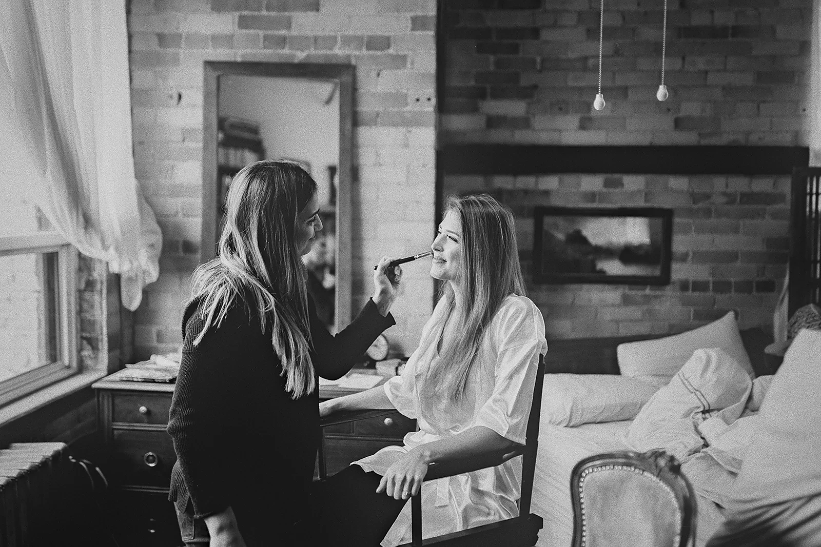 The bride gets her makeup done in a loft apartment