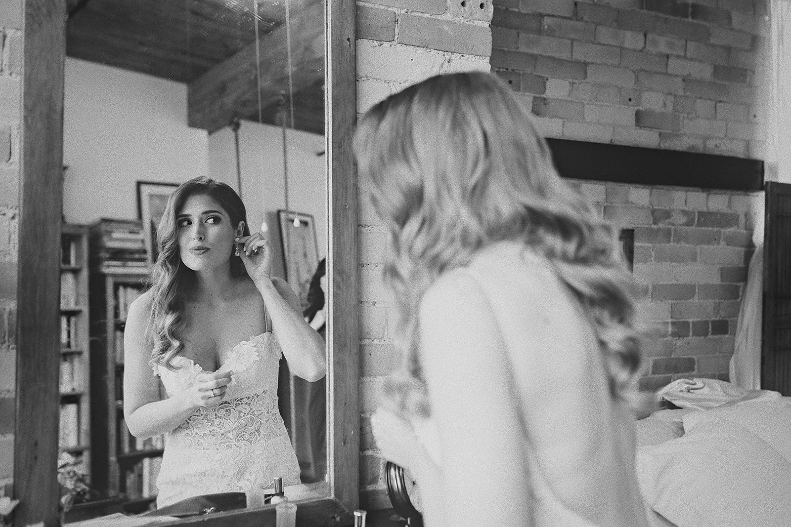 Daniela puts on her earrings while looking in the mirror