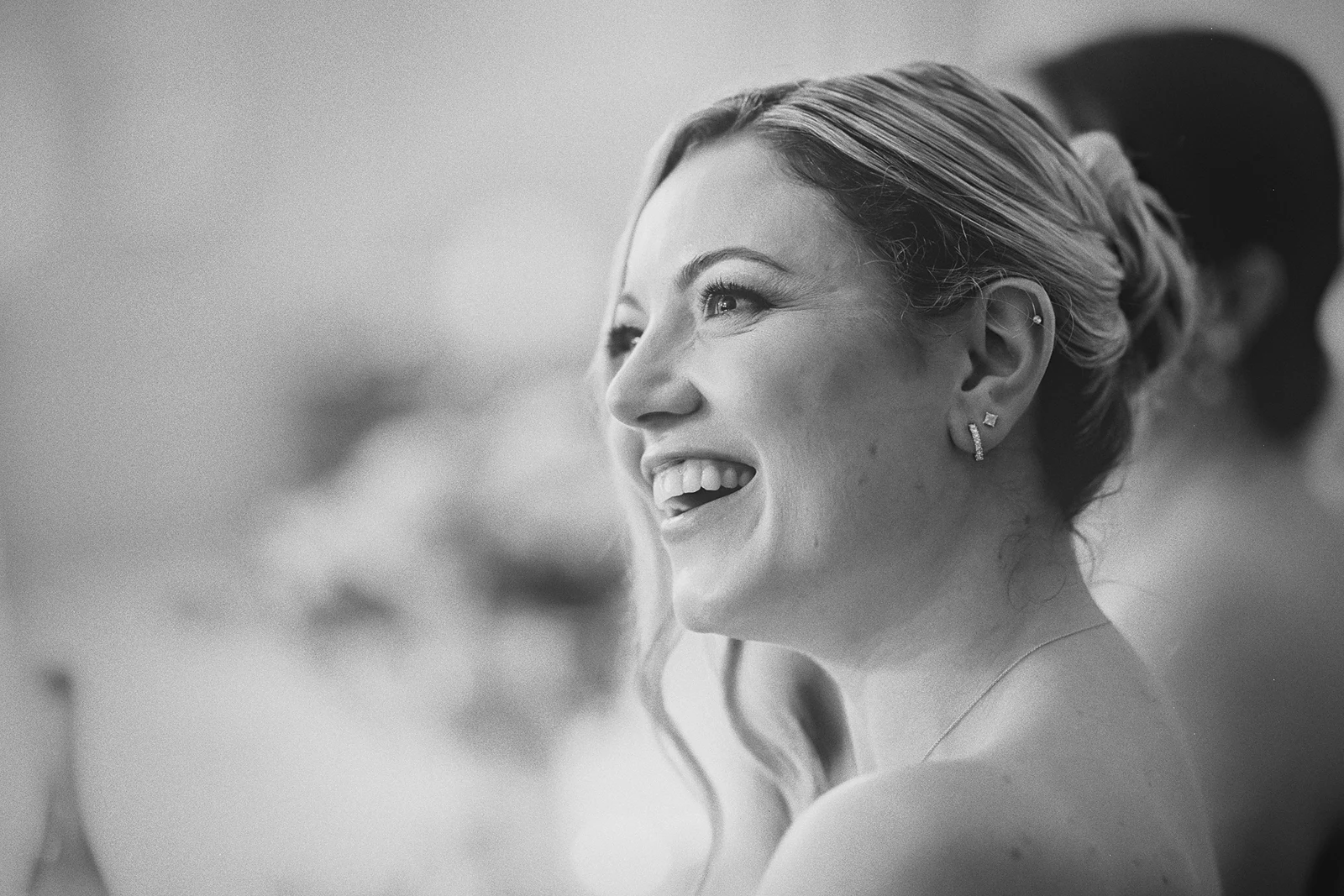 A bridesmaid laughs during a wedding toast.