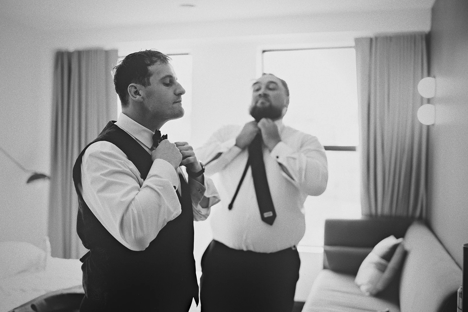 The groom and a groomsman adjust their ties