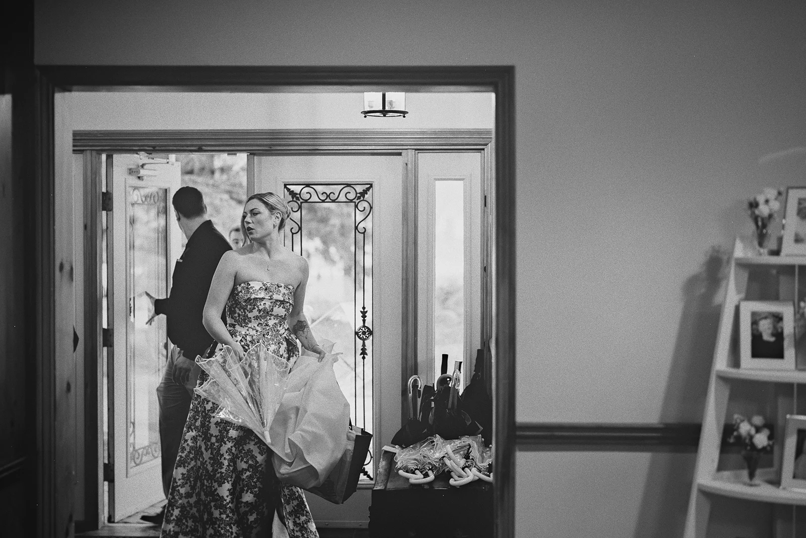 A bridesmaid carries items through a doorway