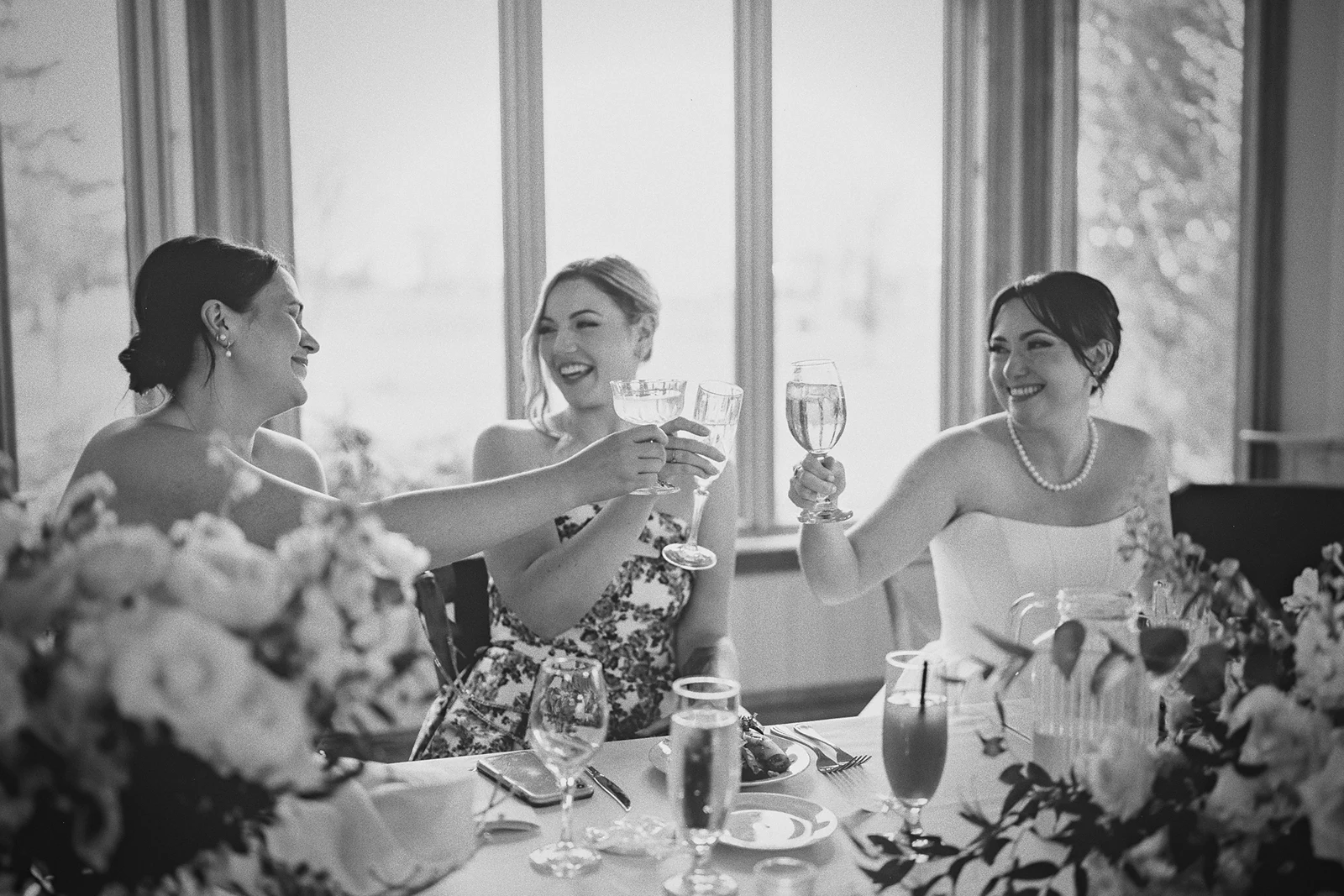 The bride and bridesmaids toast at the head table