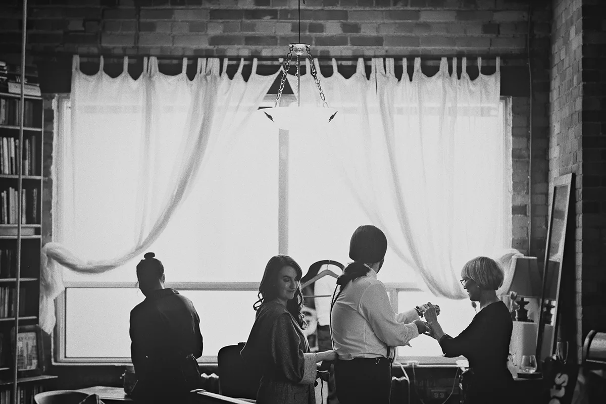 The wedding party gets ready by a large window