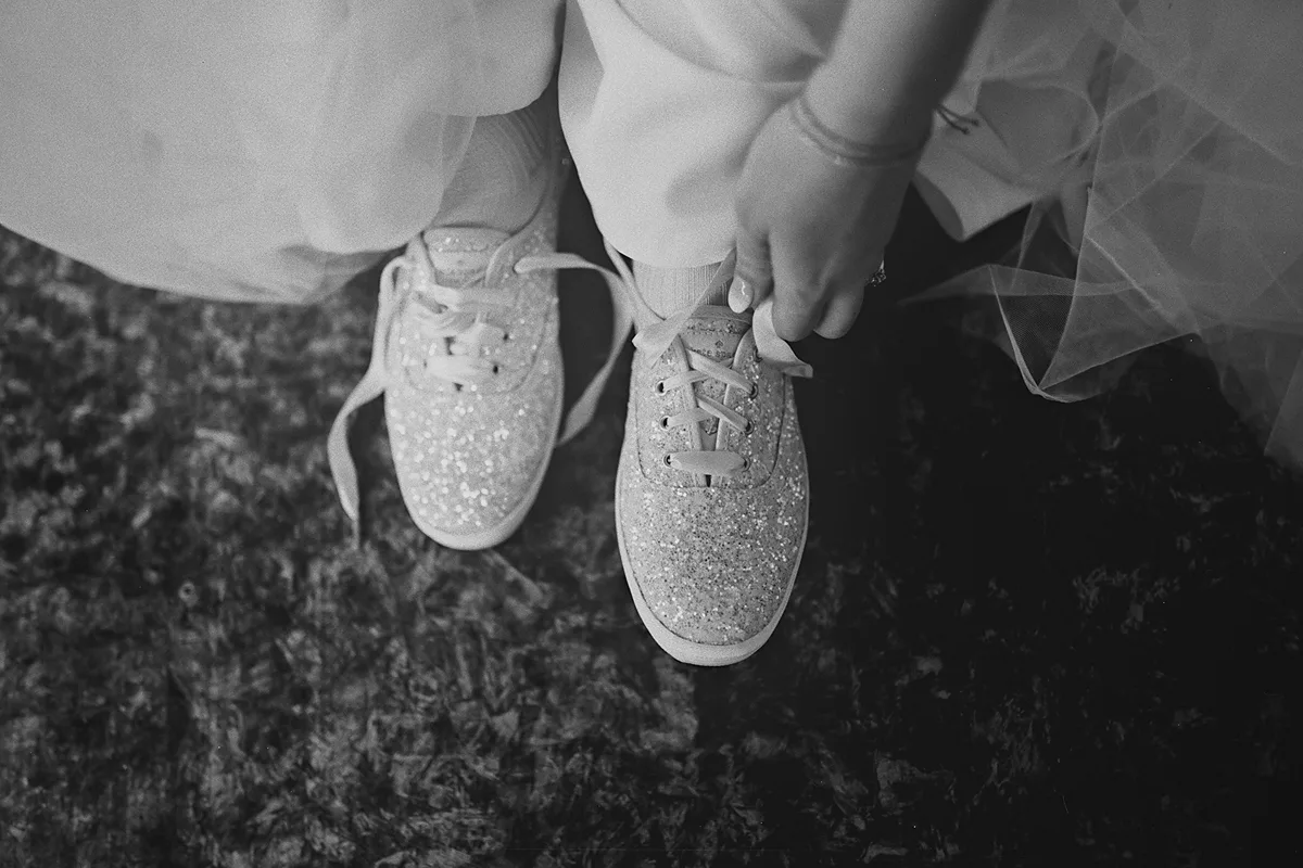 An overhead view of the bride tying her shoes