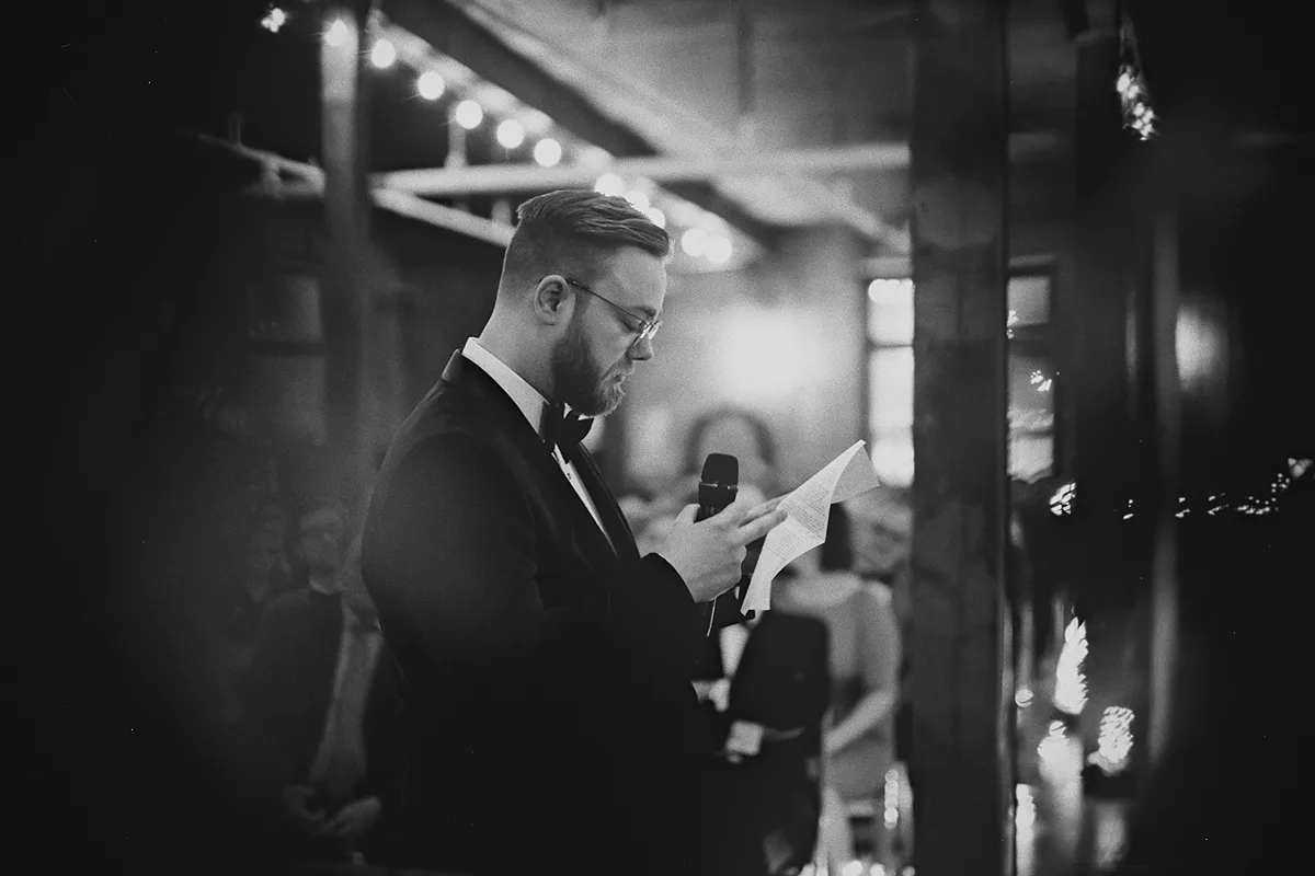 Alex reads his vows, framed by the venue's greenery.