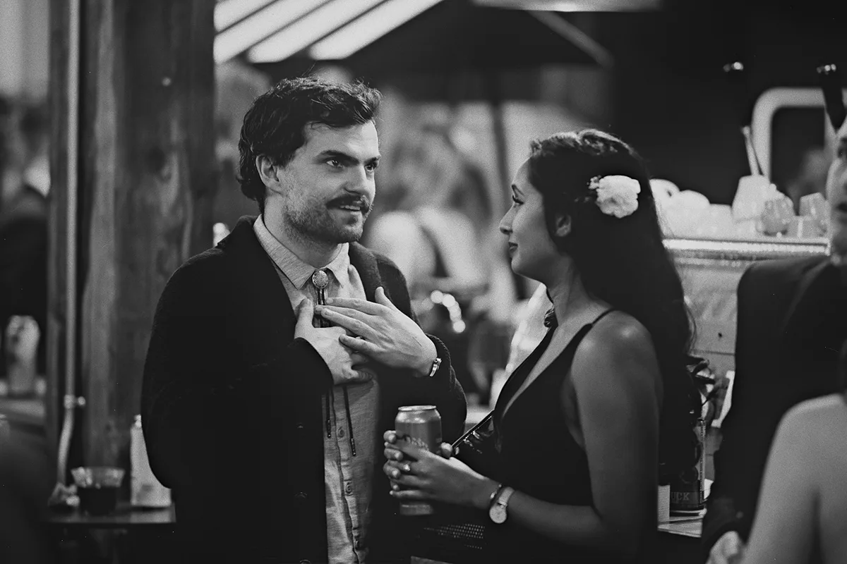 A groomsman talks with a bridesmaid.