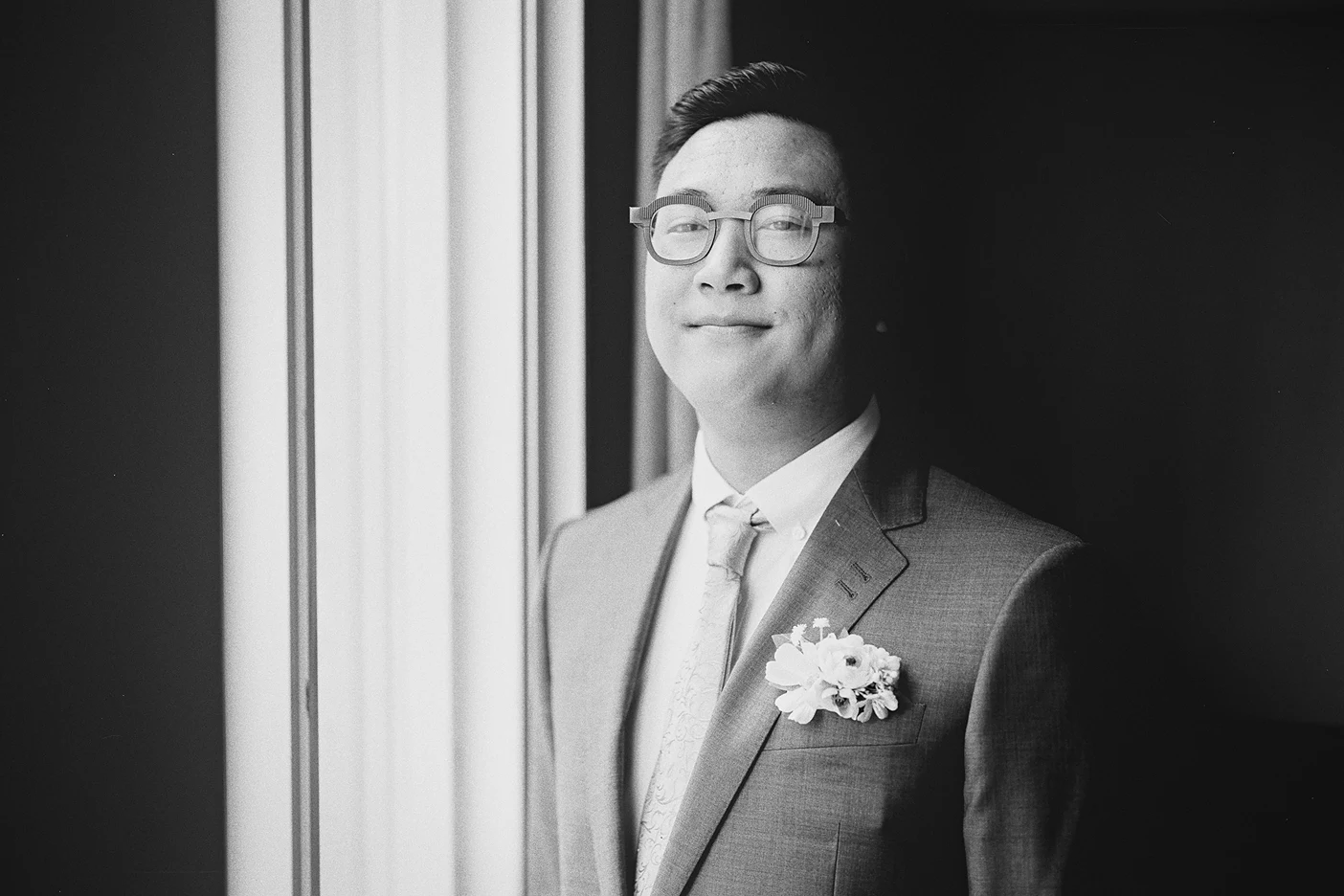 Ky stands by a window for a portrait, the natural light illuminating his features.