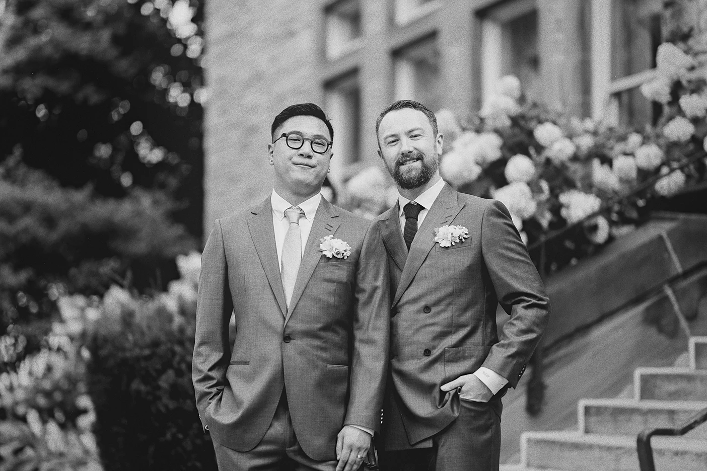 The couple poses for a classic portrait on the steps of a stone building.