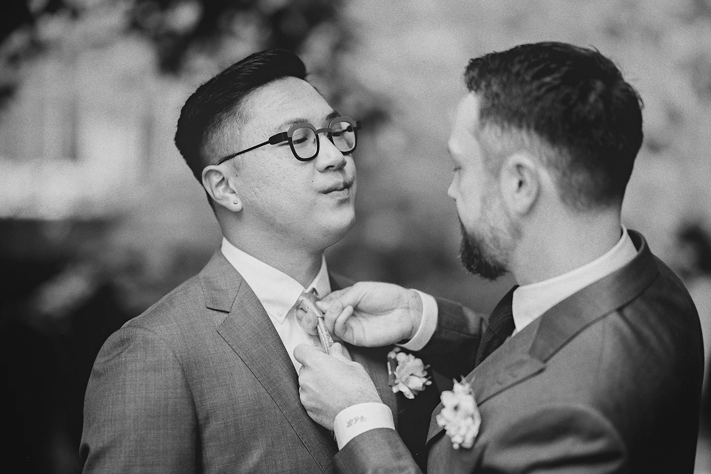 Connor makes a final adjustment to Ky's tie during their outdoor photo session.