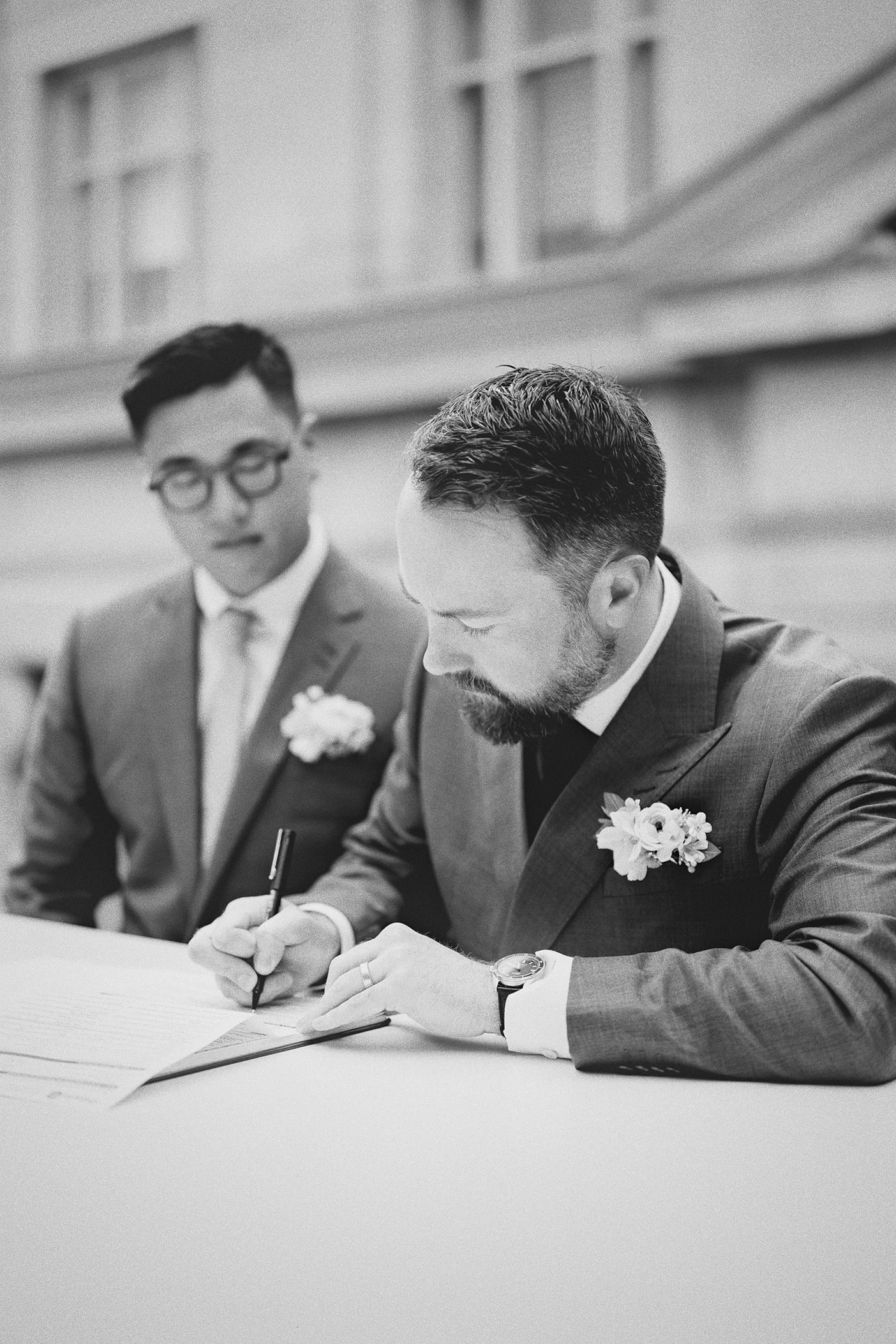 Connor carefully signs his name on the marriage license.