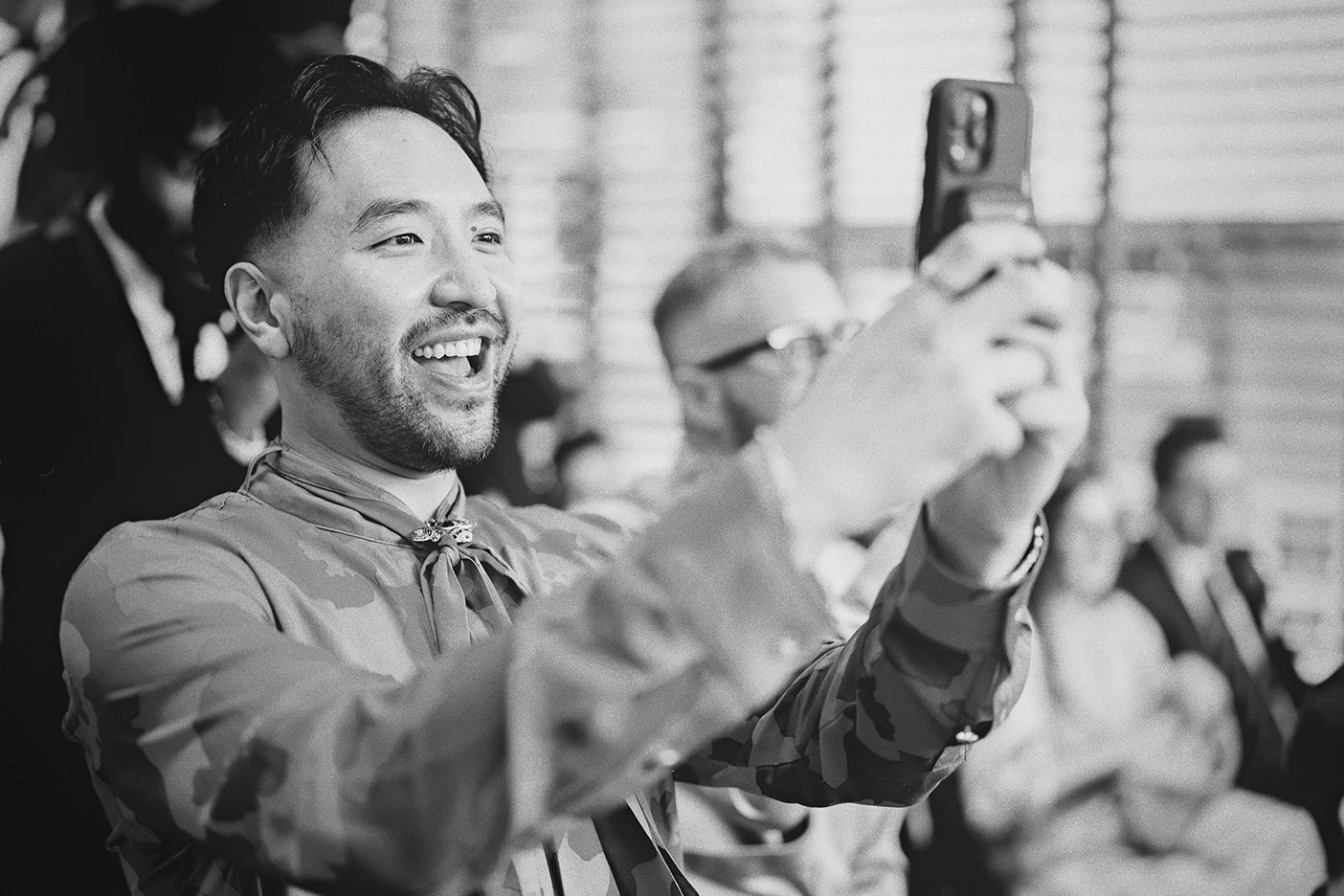 A guest enthusiastically takes a photo of the couple during the ceremony.