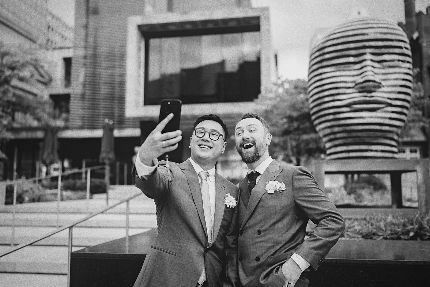 The couple takes a selfie with a large sculpture outside the museum.