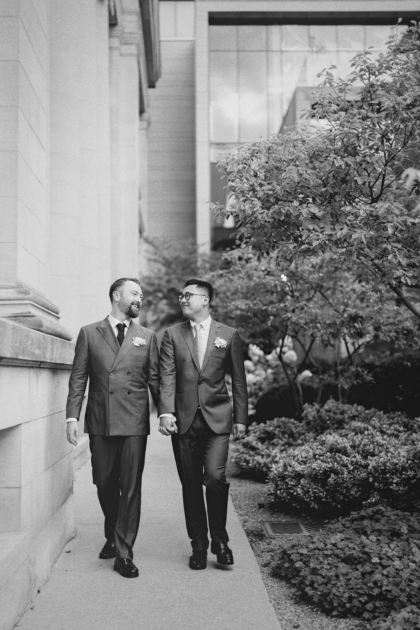 The couple walks hand-in-hand through the gardens outside the museum.