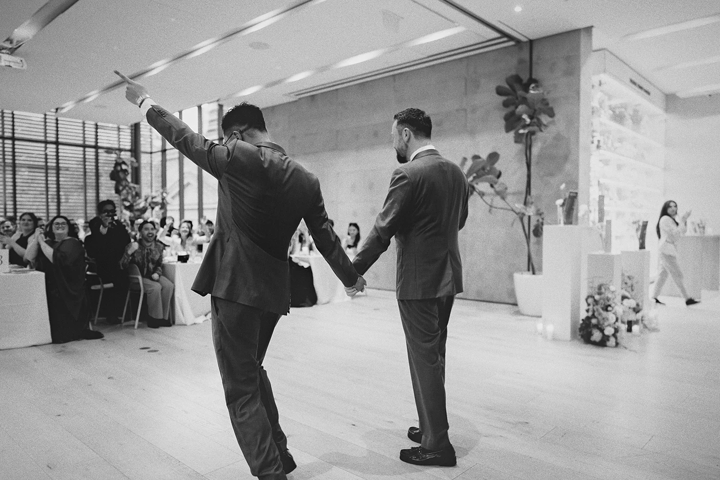 Ky raises his arm in celebration as the couple enters the reception.