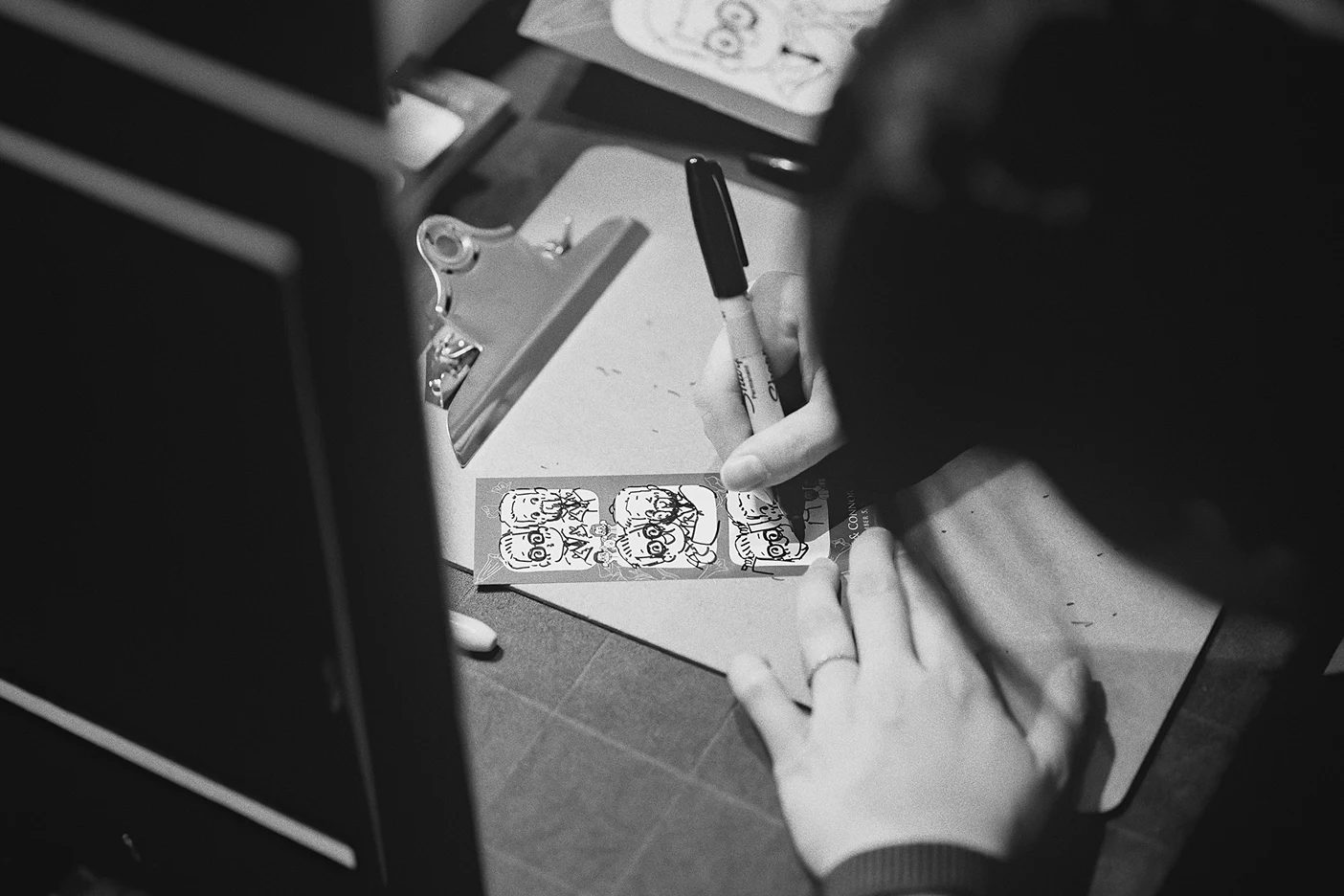 An artist adds detail to a guest's live doodle portrait.