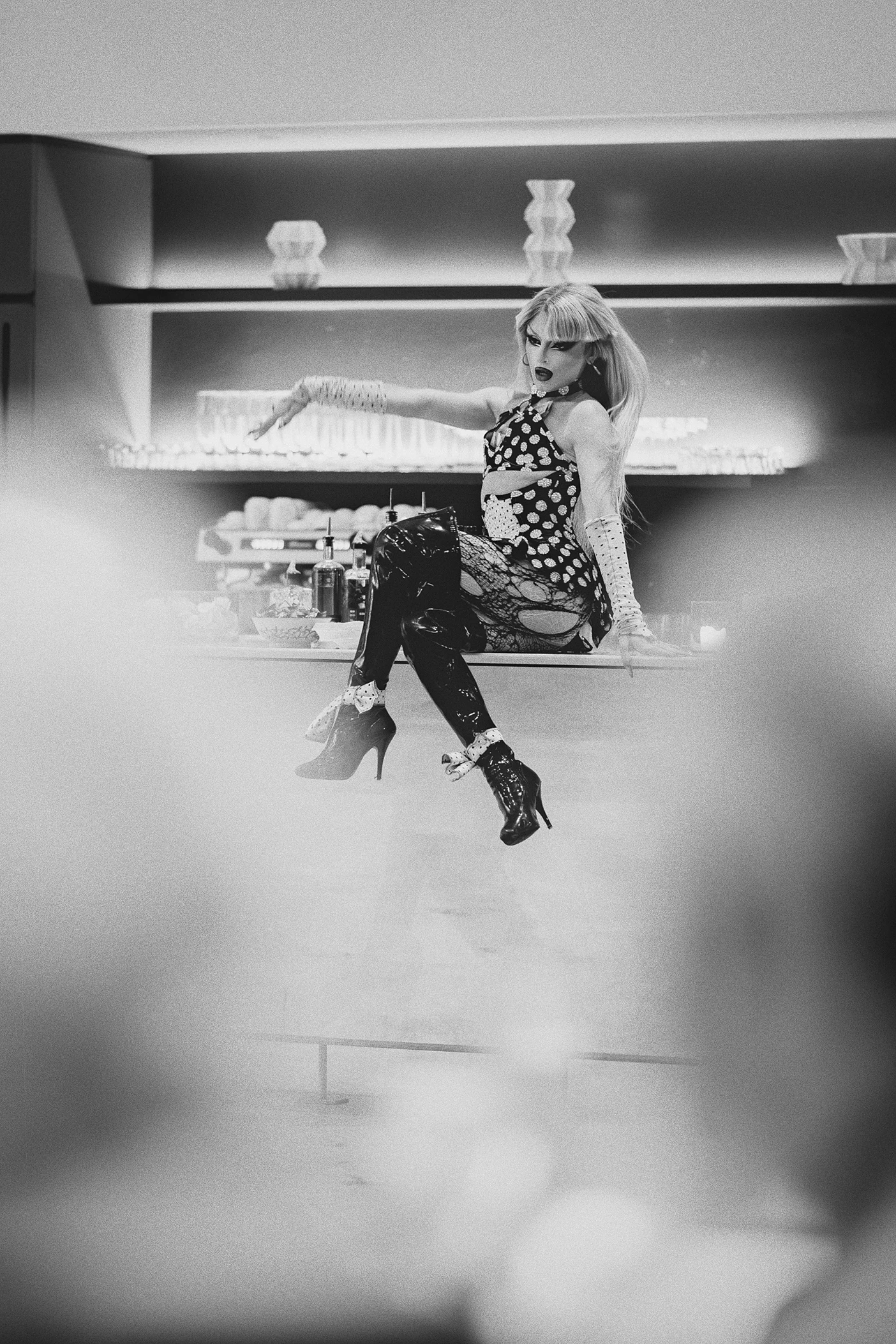 A drag queen poses on the bar during her performance.