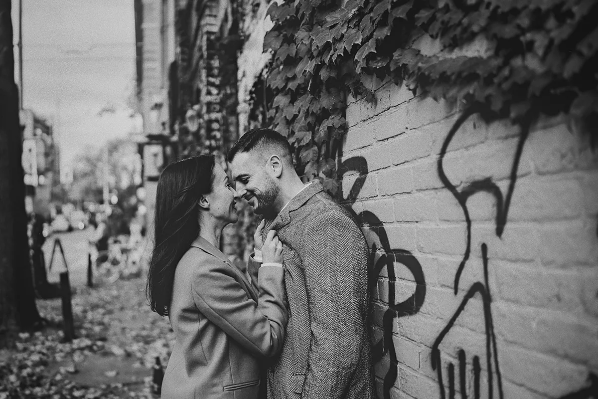 An intimate moment as the couple embraces against a wall.