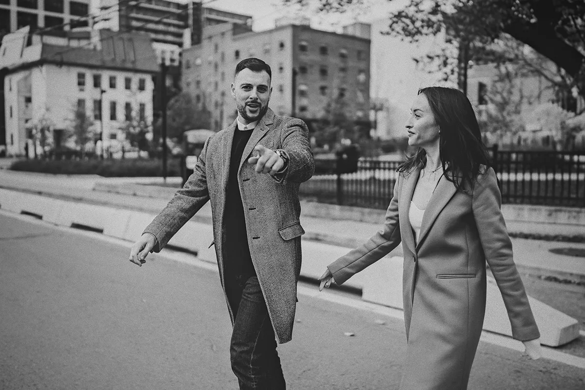 Mike playfully points while crossing the street with Roxy.