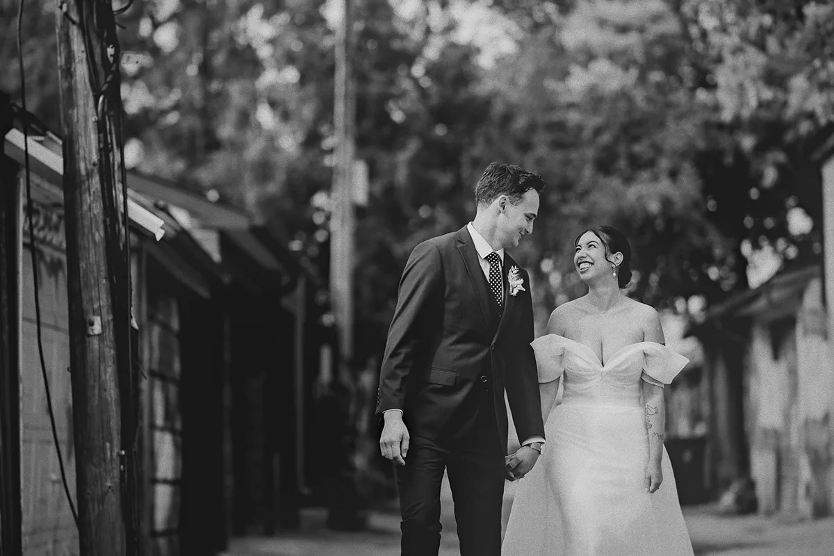 The couple walks hand-in-hand down an alley.