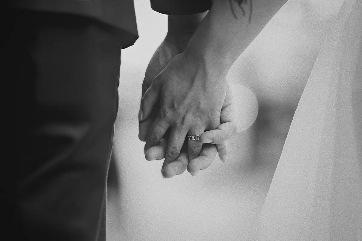 A detail shot of the couple's intertwined hands.